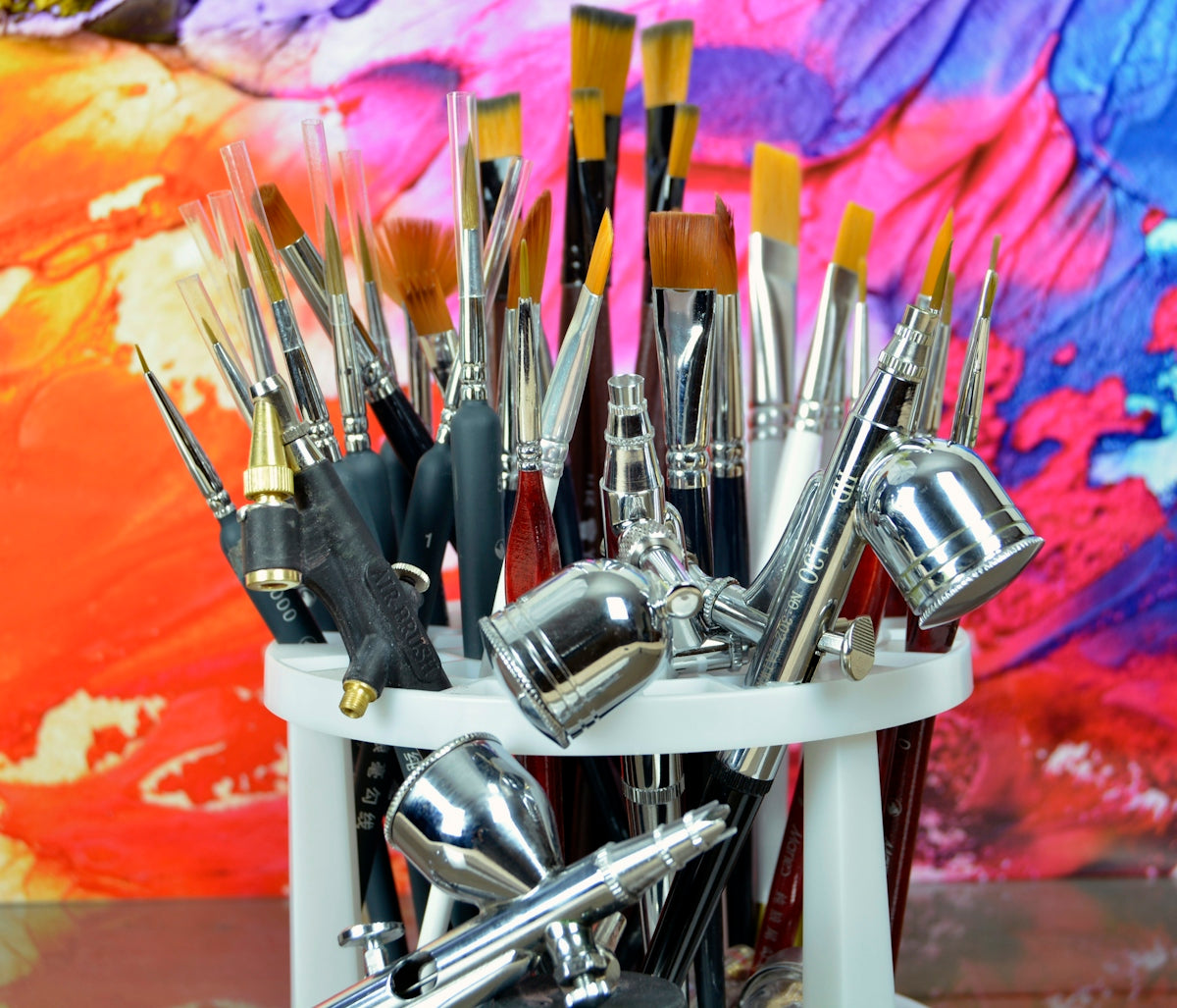 silver and black makeup brushes in white container