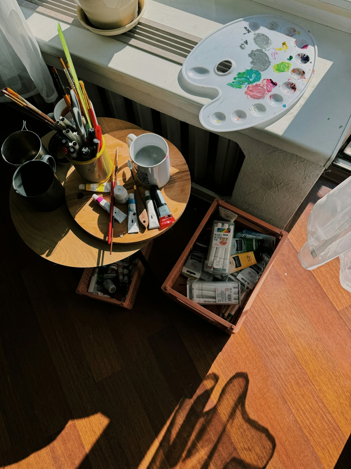 a wooden table topped with lots of art supplies
