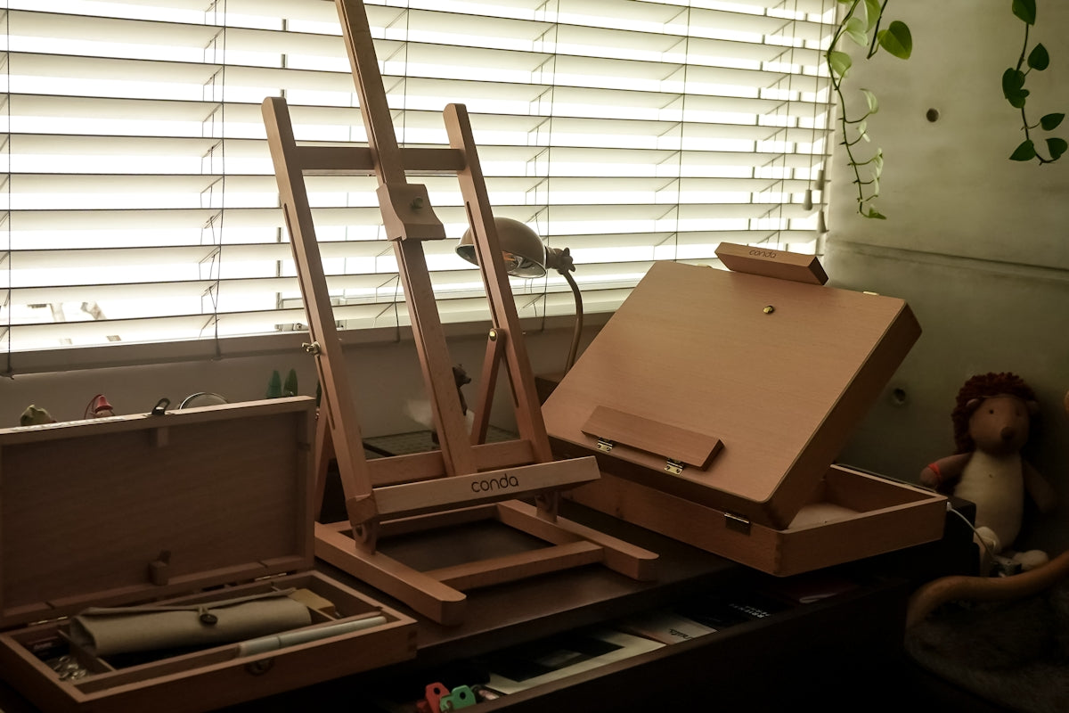 Artist's easel and art supplies in a studio.