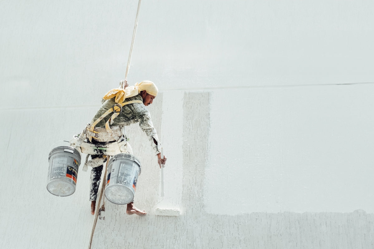 A painter is painting a white wall.