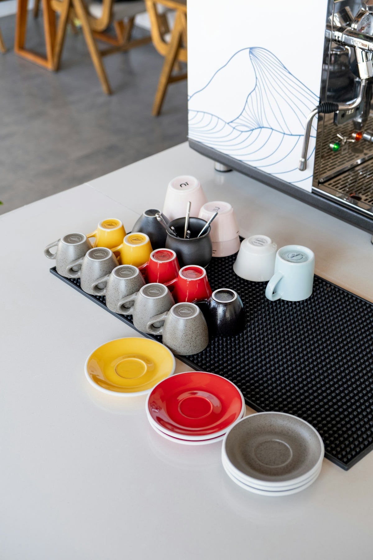 Colorful coffee cups and saucers arranged on a counter.