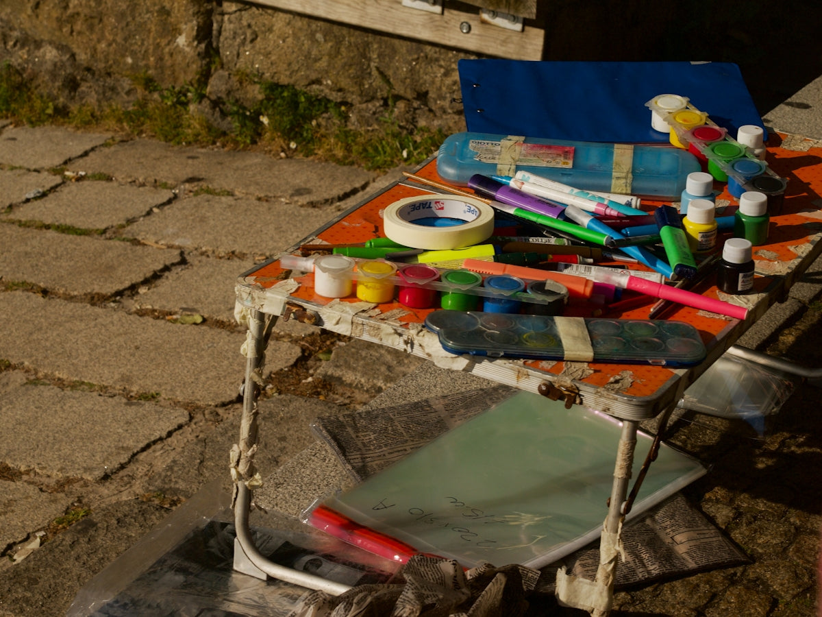 Art supplies like paints and markers on a small table.