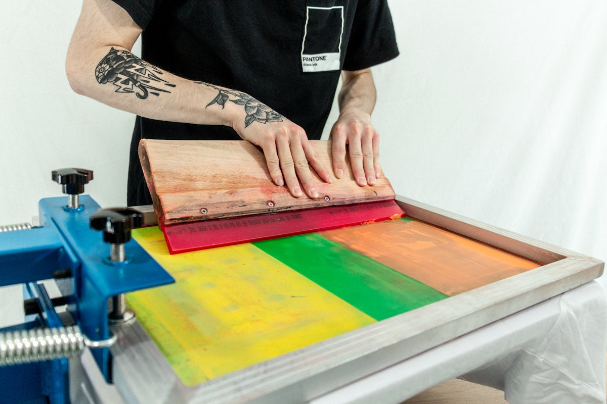 man in black t-shirt standing beside brown wooden table