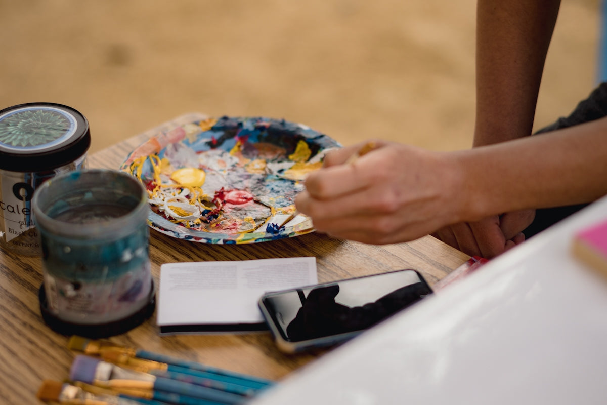 a person is painting a plate on a table
