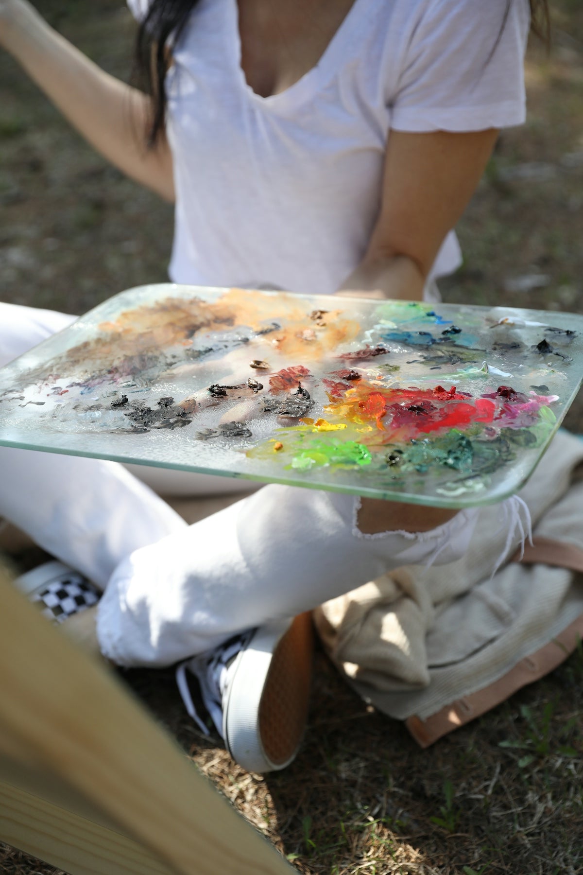 a woman sitting on the ground holding a glass plate