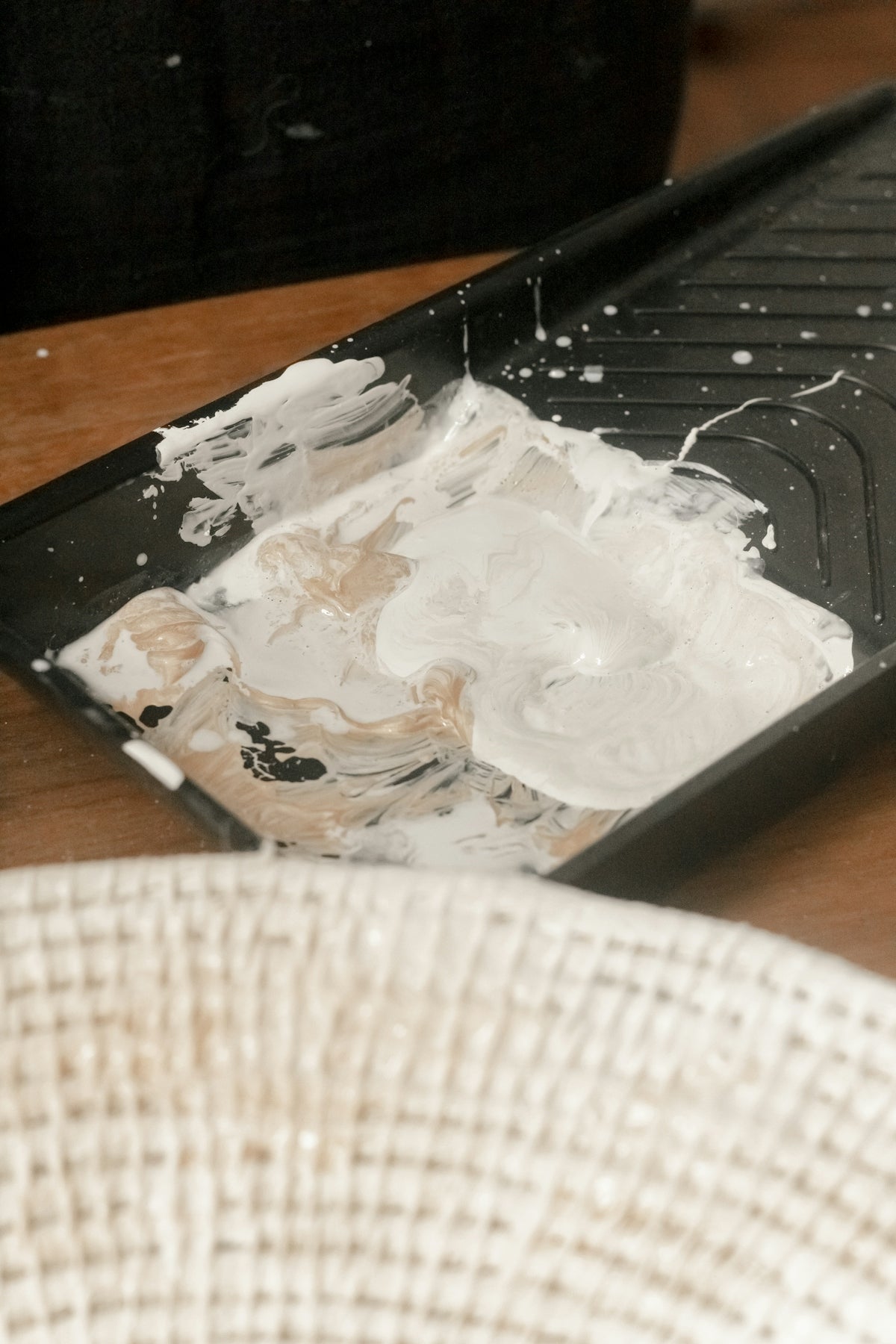 a table with a black tray with white paint on it