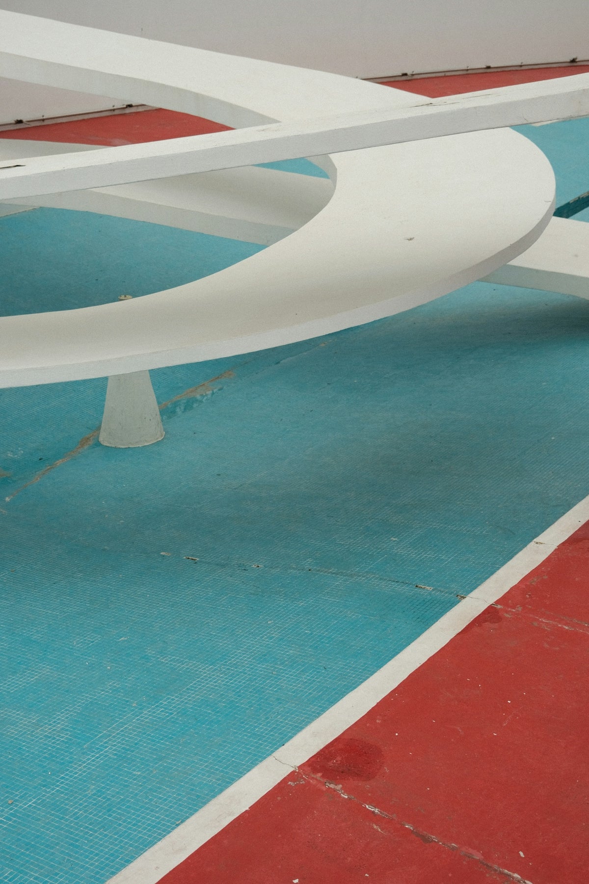 a white bench sitting on top of a blue and red floor